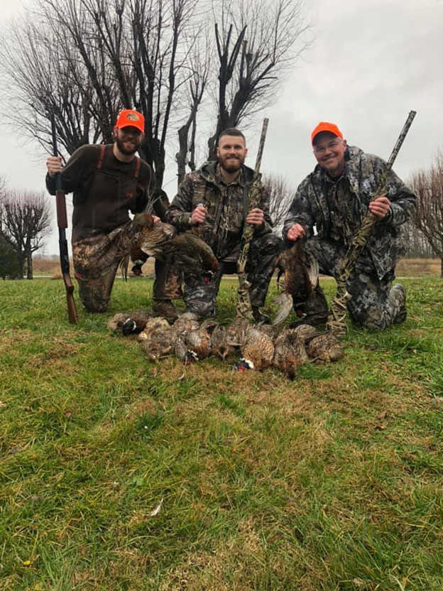 Hunters posing with pheasants they shot