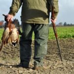 Hunter with his rifle and pheasant he hunted